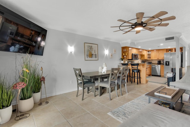 dining area with light tile patterned floors, ornamental molding, and ceiling fan