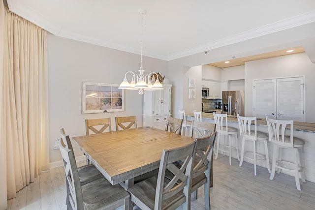 dining area with crown molding, a chandelier, and light hardwood / wood-style floors