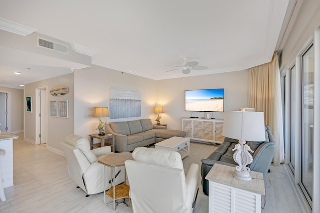 living room featuring ornamental molding, ceiling fan, and light wood-type flooring