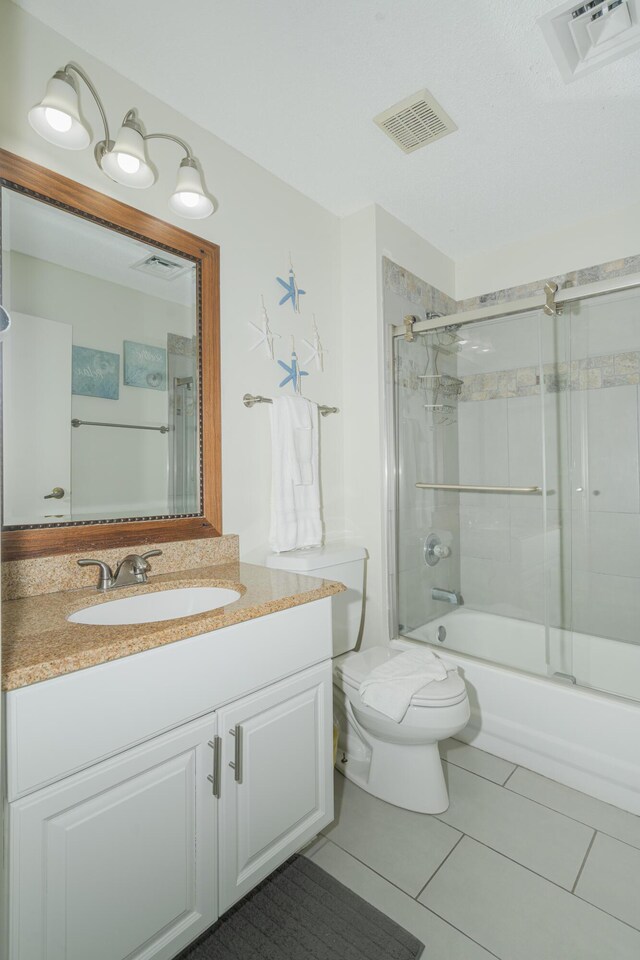 full bathroom featuring vanity, toilet, enclosed tub / shower combo, and tile patterned floors