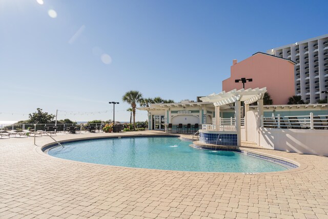 view of pool with a patio area, pool water feature, and a pergola