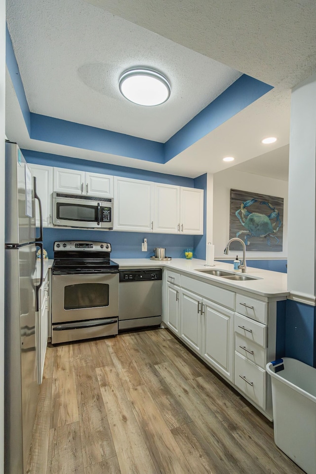 kitchen featuring sink, white cabinetry, stainless steel appliances, and a textured ceiling