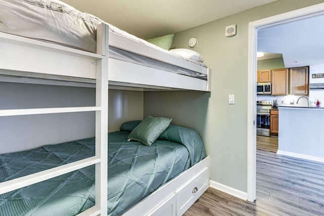 bedroom with sink and hardwood / wood-style flooring