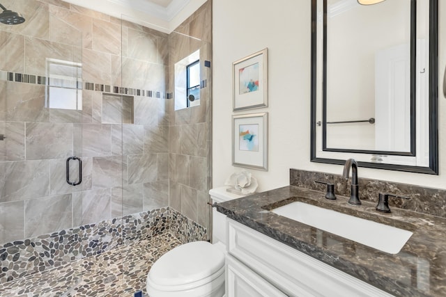 bathroom with a shower with door, crown molding, vanity, and toilet