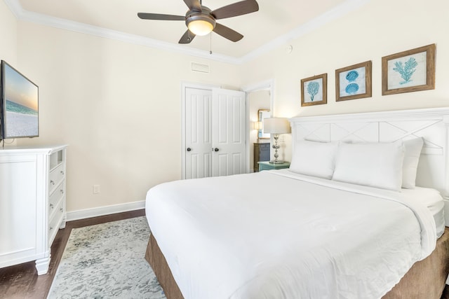 bedroom with dark hardwood / wood-style floors, ornamental molding, a closet, and ceiling fan