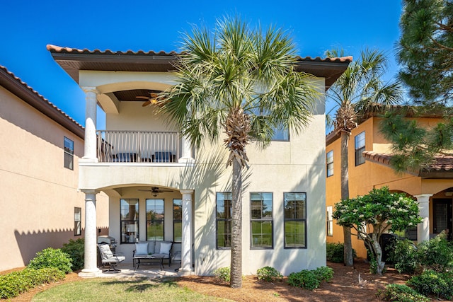 rear view of property featuring a patio, a balcony, outdoor lounge area, and ceiling fan