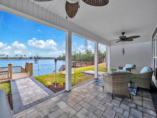 view of patio featuring an outdoor living space, a deck with water view, and ceiling fan