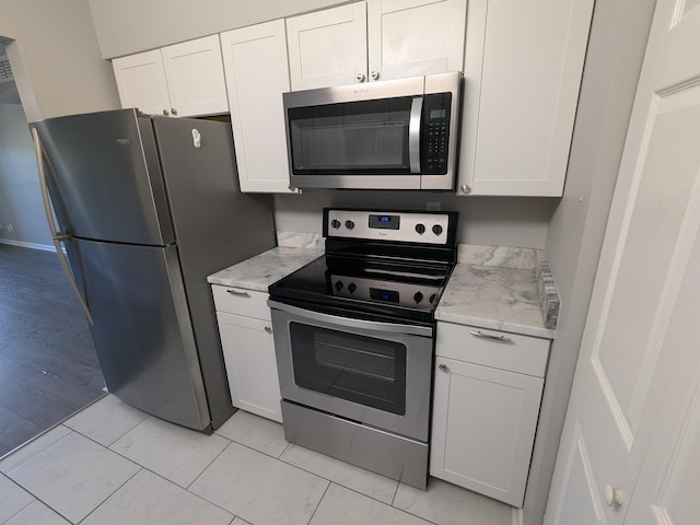 kitchen featuring white cabinets, light stone countertops, and stainless steel appliances