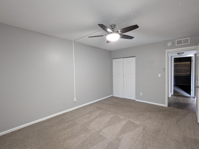 unfurnished bedroom featuring a closet, ceiling fan, and dark colored carpet