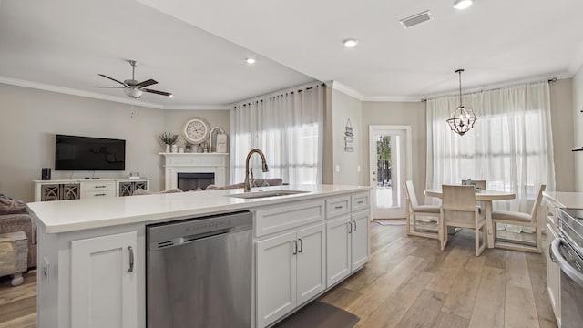 kitchen featuring white cabinetry, dishwasher, sink, hanging light fixtures, and a center island with sink