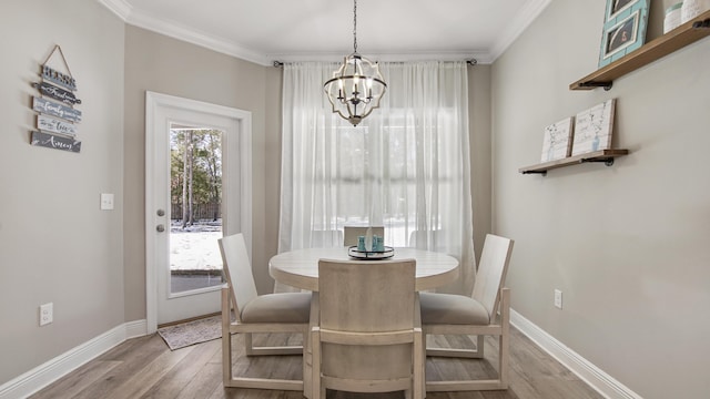 dining area featuring ornamental molding, a notable chandelier, and light hardwood / wood-style floors