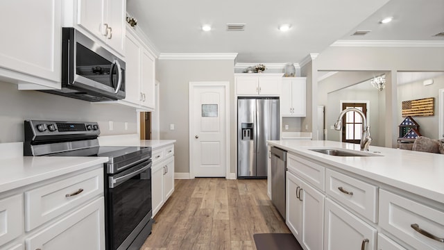 kitchen featuring appliances with stainless steel finishes, light hardwood / wood-style floors, sink, and white cabinets