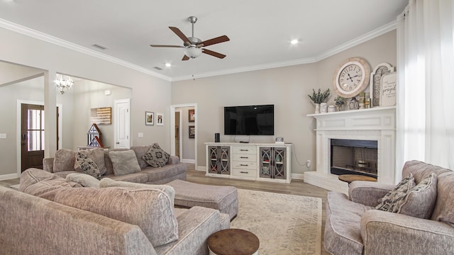 living room featuring ornamental molding, a brick fireplace, ceiling fan, and light wood-type flooring