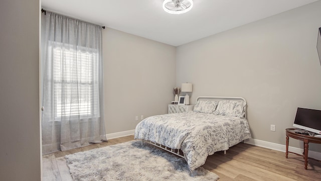 bedroom with multiple windows and light hardwood / wood-style floors