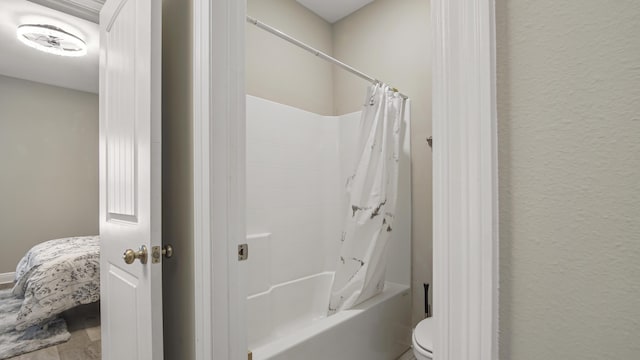 bathroom with hardwood / wood-style flooring and shower / bath combo with shower curtain