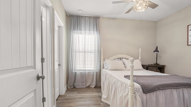 bedroom with multiple windows, light hardwood / wood-style floors, and ceiling fan