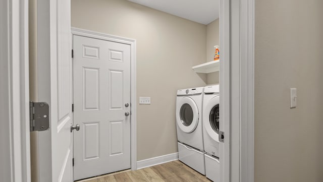 laundry room featuring light hardwood / wood-style floors and washer and dryer