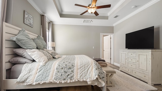 bedroom featuring hardwood / wood-style flooring, ceiling fan, and a tray ceiling