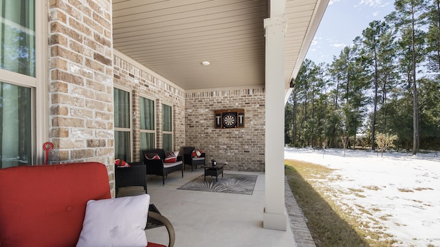 snow covered patio featuring an outdoor hangout area