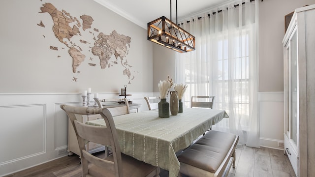 dining space featuring hardwood / wood-style flooring and crown molding