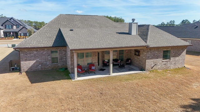 rear view of property with a yard and a patio