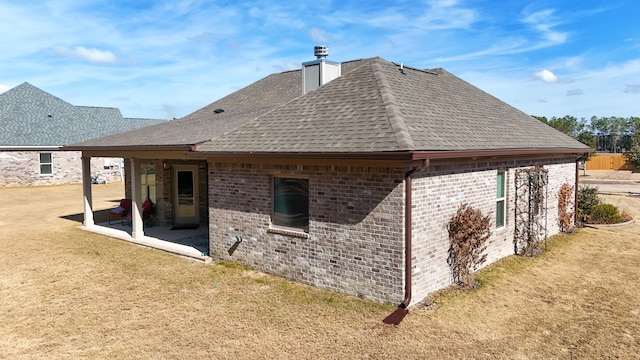 back of property with a lawn and a patio