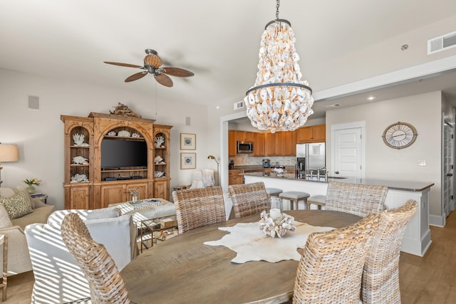 dining space featuring light hardwood / wood-style floors and ceiling fan with notable chandelier