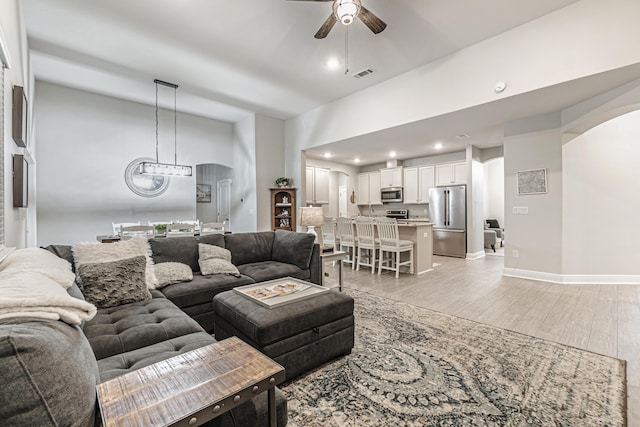 living room with ceiling fan and light wood-type flooring