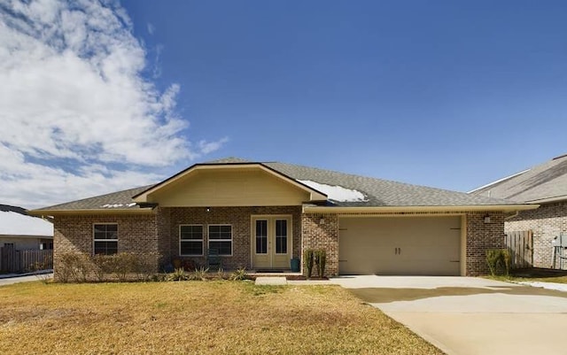 ranch-style home featuring a garage and a front lawn