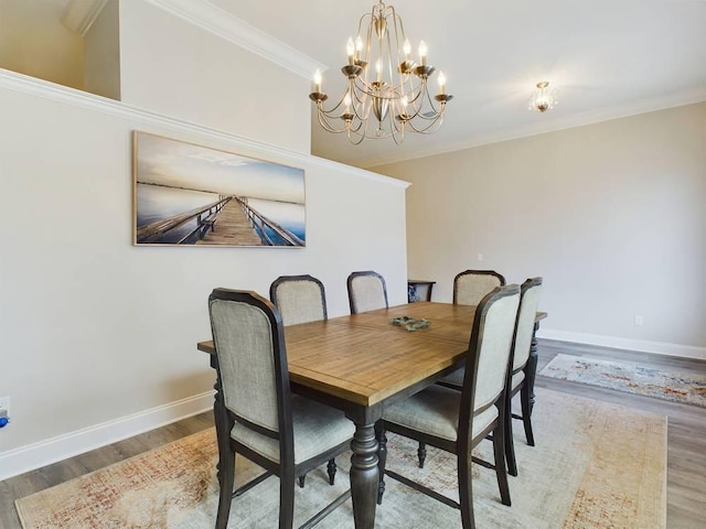 dining room with hardwood / wood-style flooring, ornamental molding, and an inviting chandelier