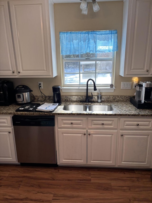 kitchen featuring dishwasher, sink, and white cabinets