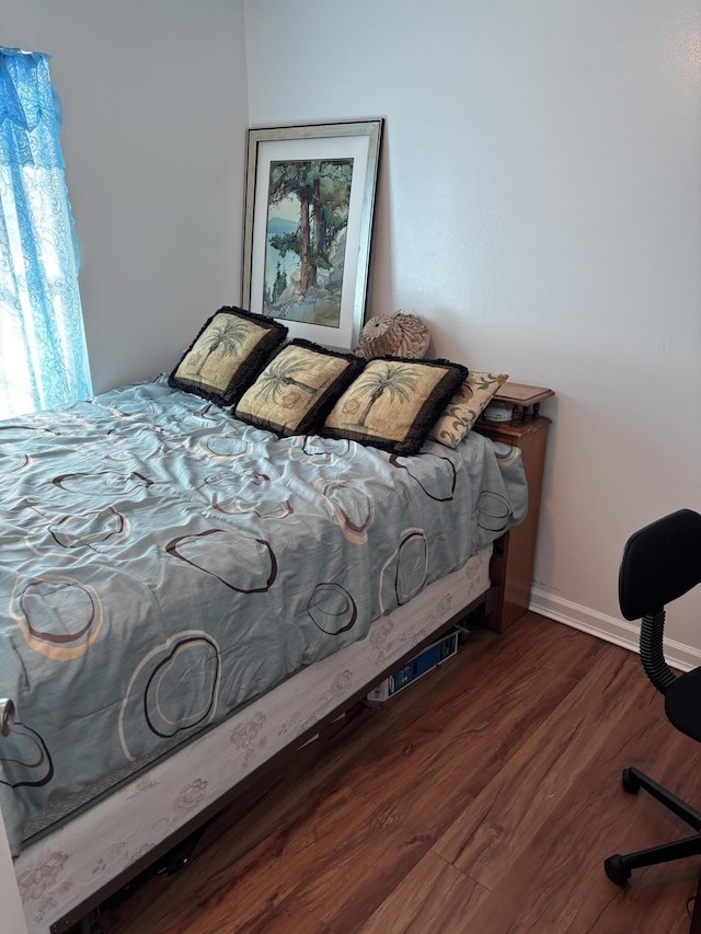 bedroom with dark hardwood / wood-style flooring