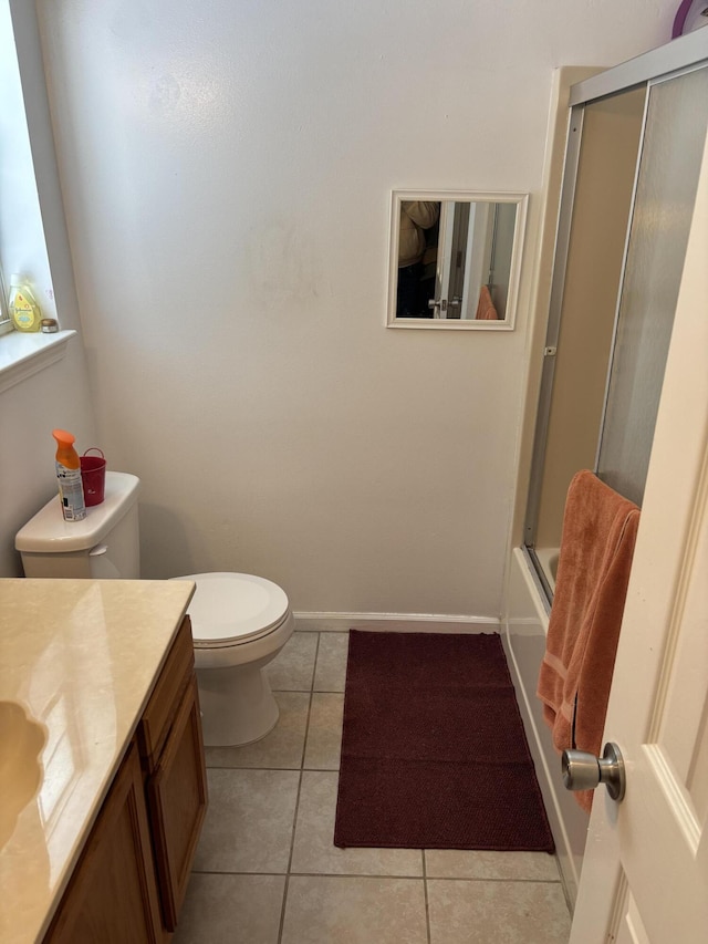 full bathroom featuring vanity, bath / shower combo with glass door, tile patterned floors, and toilet