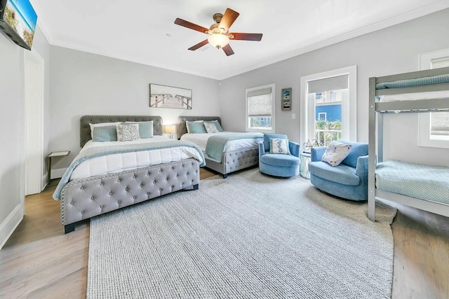 bedroom with ornamental molding, ceiling fan, and light hardwood / wood-style floors