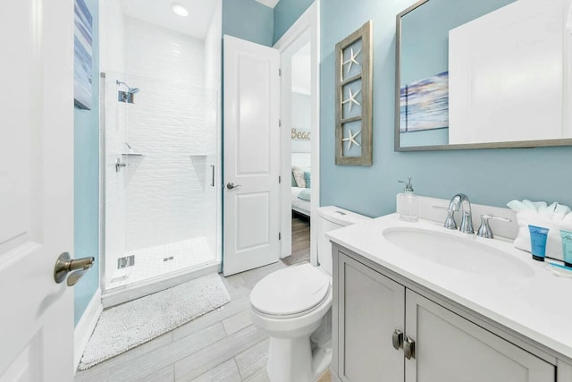 bathroom featuring vanity, a shower with shower door, toilet, and wood-type flooring