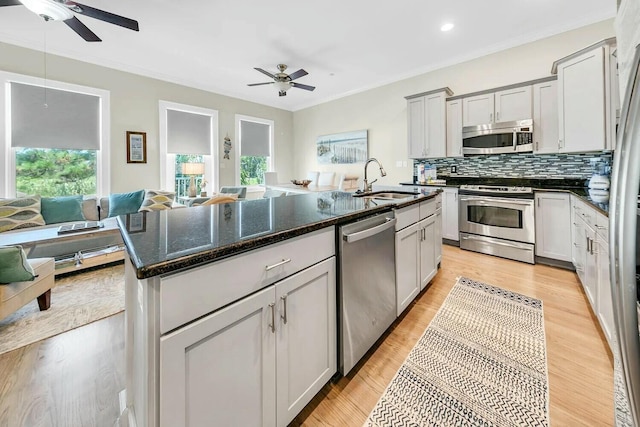 kitchen featuring a kitchen island with sink, sink, a wealth of natural light, and stainless steel appliances