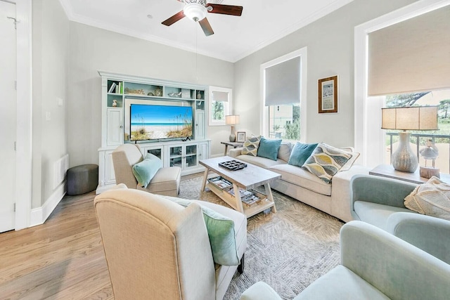 living room with ceiling fan, ornamental molding, and light hardwood / wood-style flooring