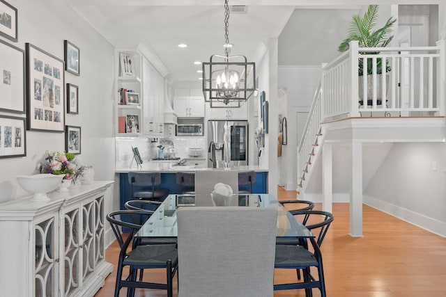 dining room with a chandelier and light hardwood / wood-style flooring