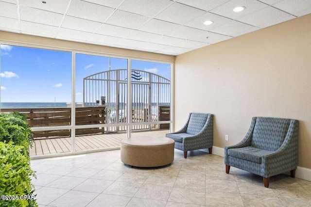 sunroom / solarium featuring a water view and a paneled ceiling