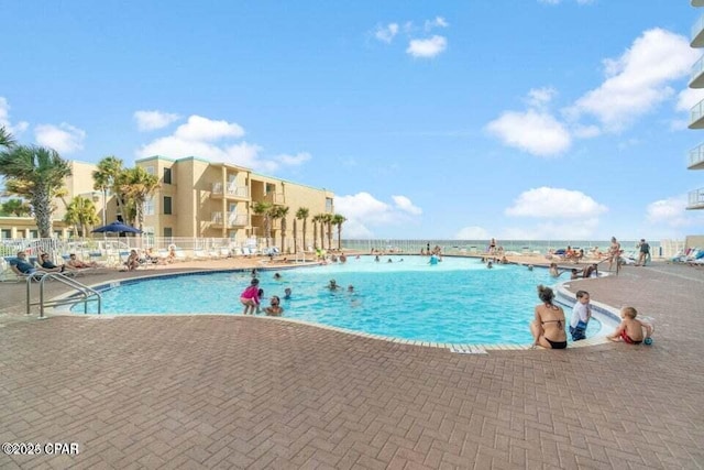 view of swimming pool with a water view and a patio