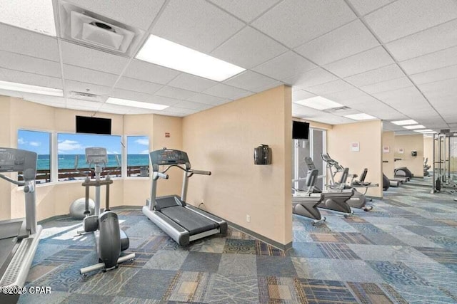 exercise room featuring carpet floors and a drop ceiling