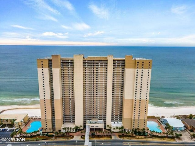 birds eye view of property with a water view and a beach view