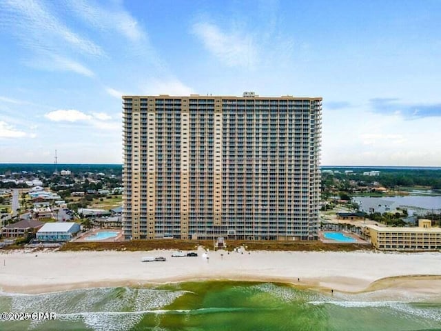 view of building exterior featuring a view of the beach and a water view