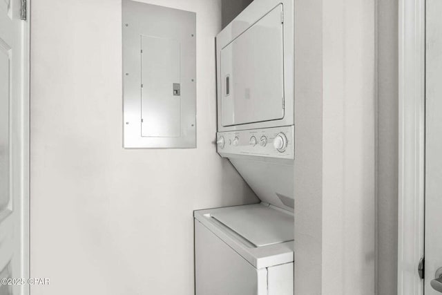 washroom featuring stacked washer / drying machine and electric panel