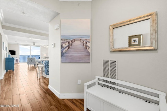 hallway featuring ornamental molding and hardwood / wood-style floors