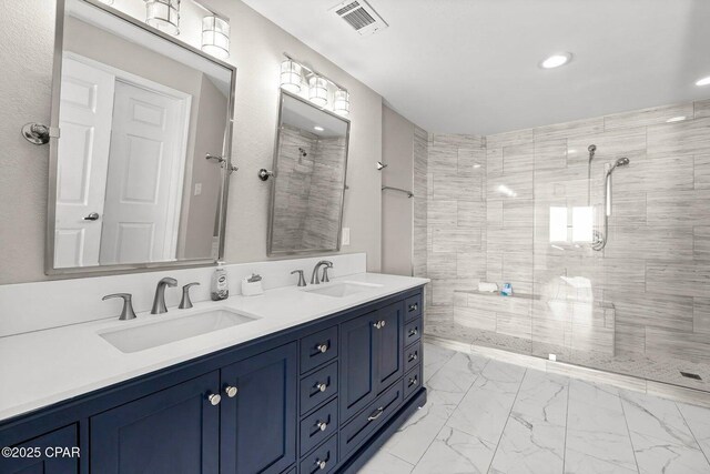 bathroom with vanity and tiled shower