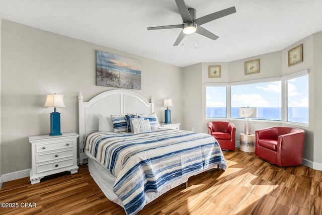 bedroom with a water view, ceiling fan, and hardwood / wood-style flooring