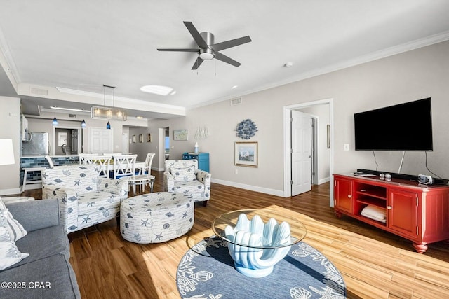 living room featuring ornamental molding, hardwood / wood-style floors, and ceiling fan