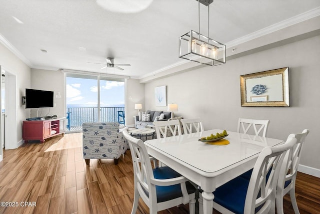 dining area featuring crown molding, ceiling fan, and light hardwood / wood-style floors