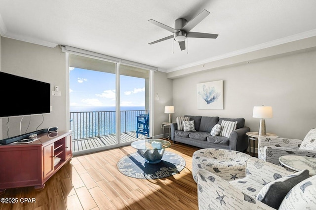 living room featuring expansive windows, ornamental molding, a water view, and light hardwood / wood-style floors